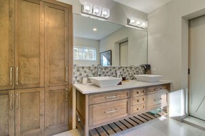 A modern bathroom with wooden cabinets, a large mirror, and two sinks. - La Brise O-Lac (Sherbrooke)