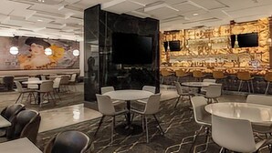 Un restaurante moderno con suelo de mármol, decoración de pared de piedra y varias zonas de estar.
