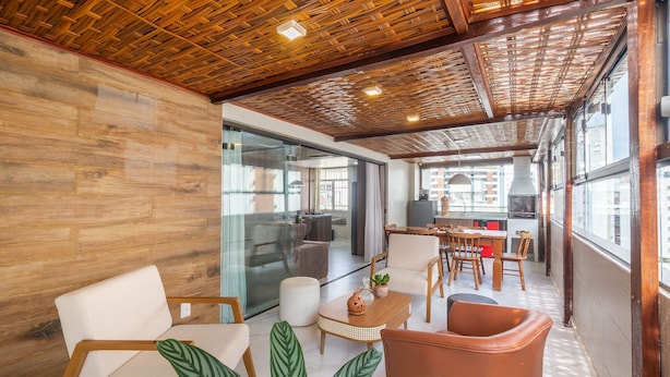 Un interior moderno con suelo de madera, una pared divisoria de vidrio y un comedor con sillas y una mesa.