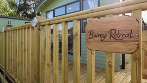 Una terraza de madera con un letrero que dice 'Barneys Retreat'.