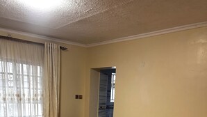 Een hotelkamer met een bed, een bureau, een stoel en een badkamer die door een open deur zichtbaar is.