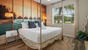 A bedroom with a bed, a nightstand, a large window, a wall mural, and a hanging light fixture. - Star Wars Theater & Pool Paradise near Disney (Kissimmee)