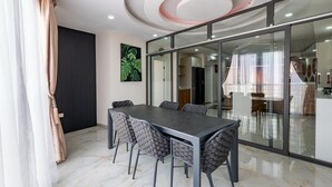 A modern dining area with a marble floor, a dark table, and grey upholstered chairs. - TERANGA ROOF-TOP MAMELLES, DAKAR (Dakar)