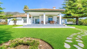 A house with a covered porch, a stone pathway, and a well-maintained lawn.