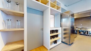 Una cocina moderna con estantes empotrados, un refrigerador de acero inoxidable y una estufa.