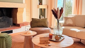 Un salon chaleureux avec une cheminée, un canapé, une table basse et un vase décoratif.