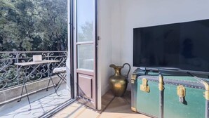 A balcony with a table, a brass pitcher, and a green suitcase with gold accents. - Design & Comfort in Porta Romana (Milan)