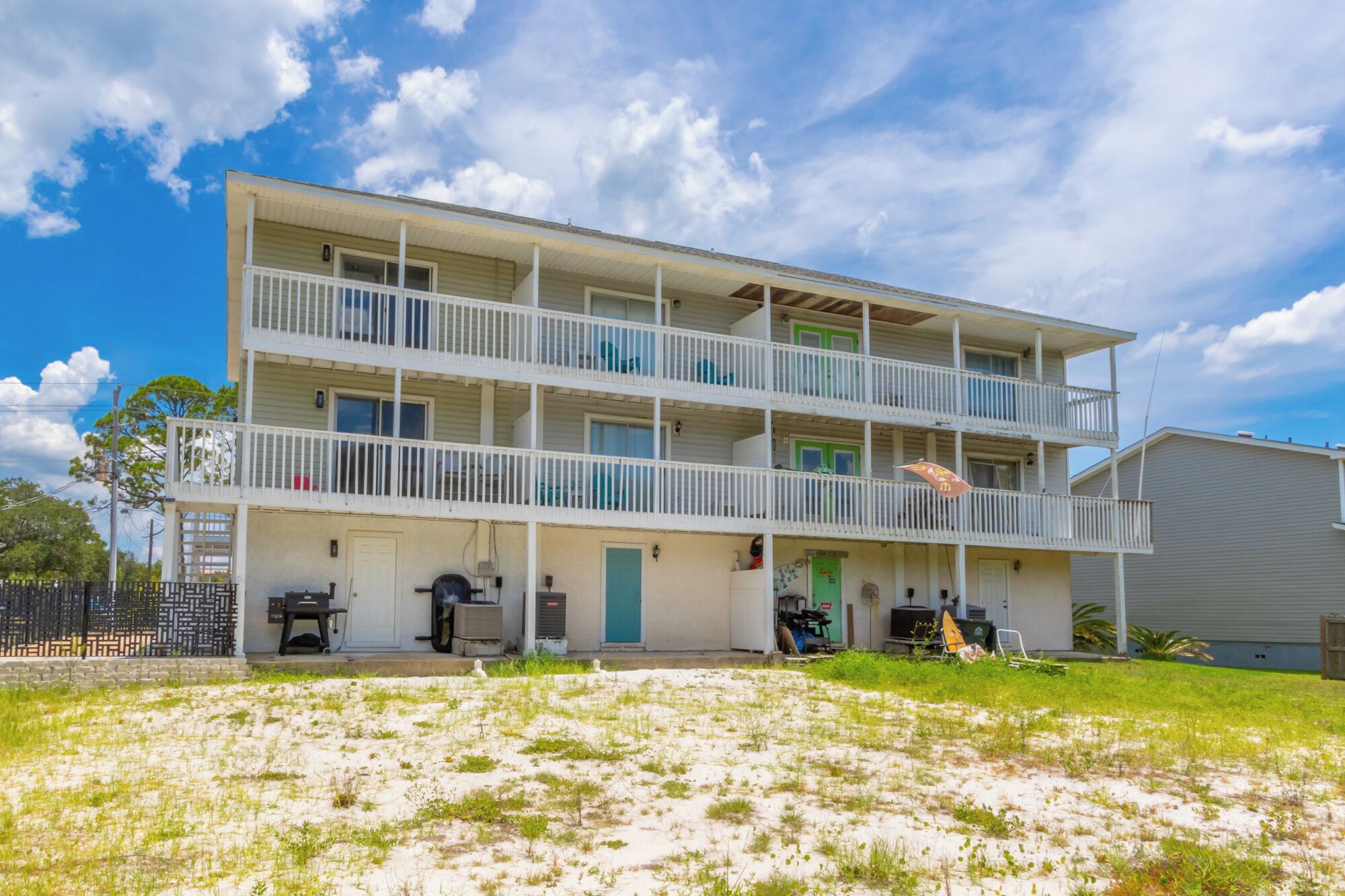 A two-story motel with a flat roof, multiple balconies, and a covered outdoor seating area.