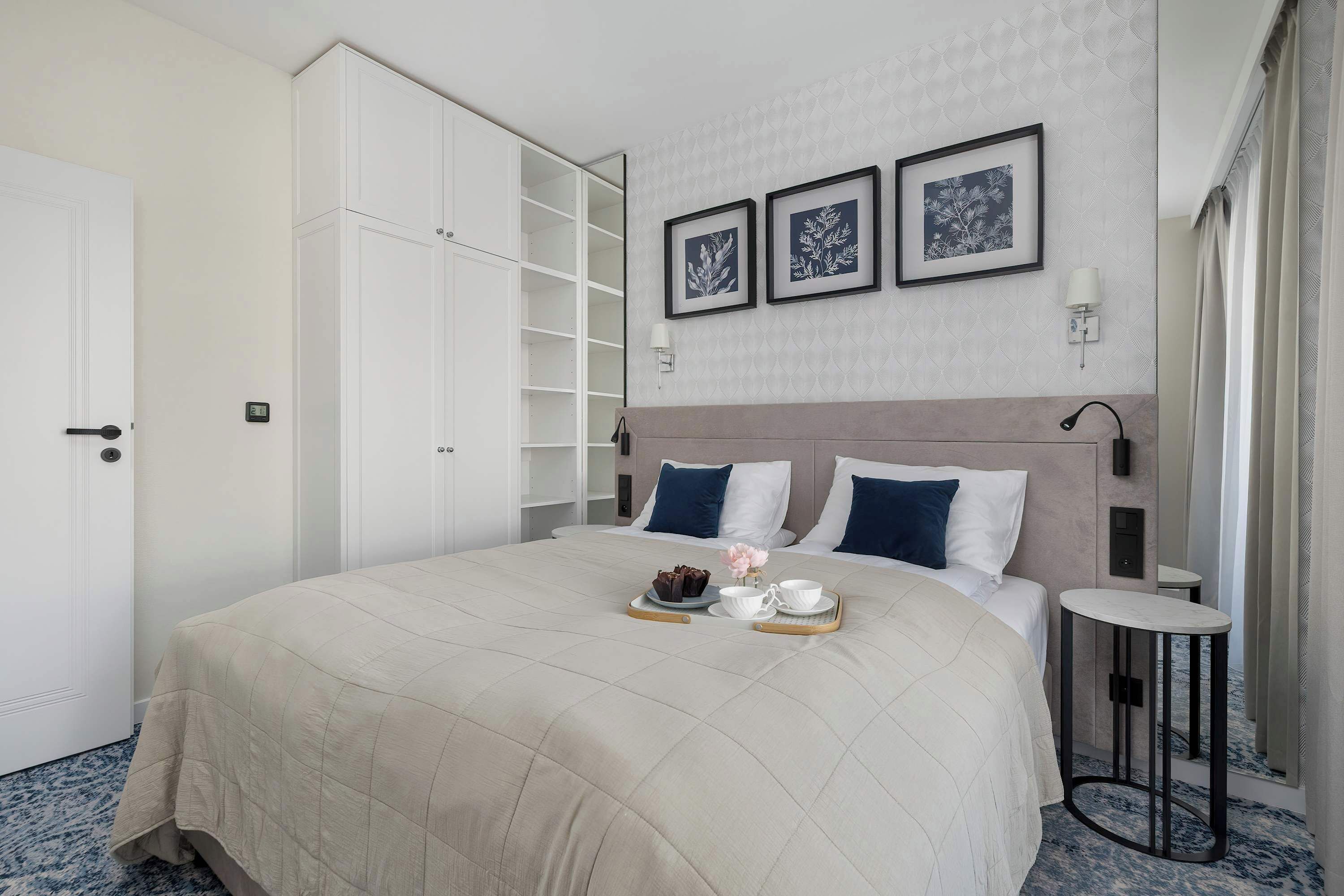 A neatly arranged bedroom with a bed, bedside table, and a wardrobe.