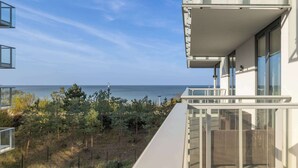 A modern building with a balcony overlooking a body of water.