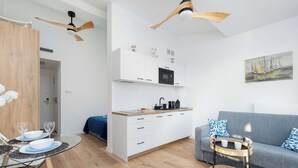 Een moderne woonruimte met keuken, eethoek en zithoek.