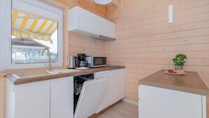 A compact kitchen with a dishwasher, a microwave, and a coffee maker.