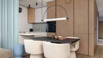 Une cuisine moderne dotée d’un îlot central, de meubles en bois et d’un luminaire suspendu.