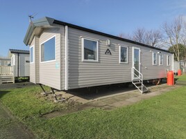 Ein Wohnmobil mit Veranda, einer kleinen Terrasse und einem sichtbaren Propantank.
