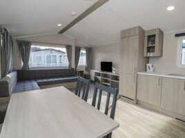 Eine moderne Küchenzeile mit Fernseher, Esstisch und Sofa.