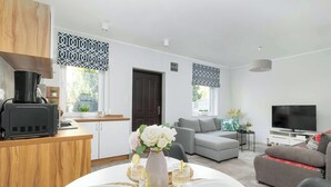 Una sala de estar moderna con un sofá, televisor y comedor con mesa para cuatro.