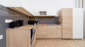 Una cocina moderna con armarios de madera, microondas y lavavajillas.