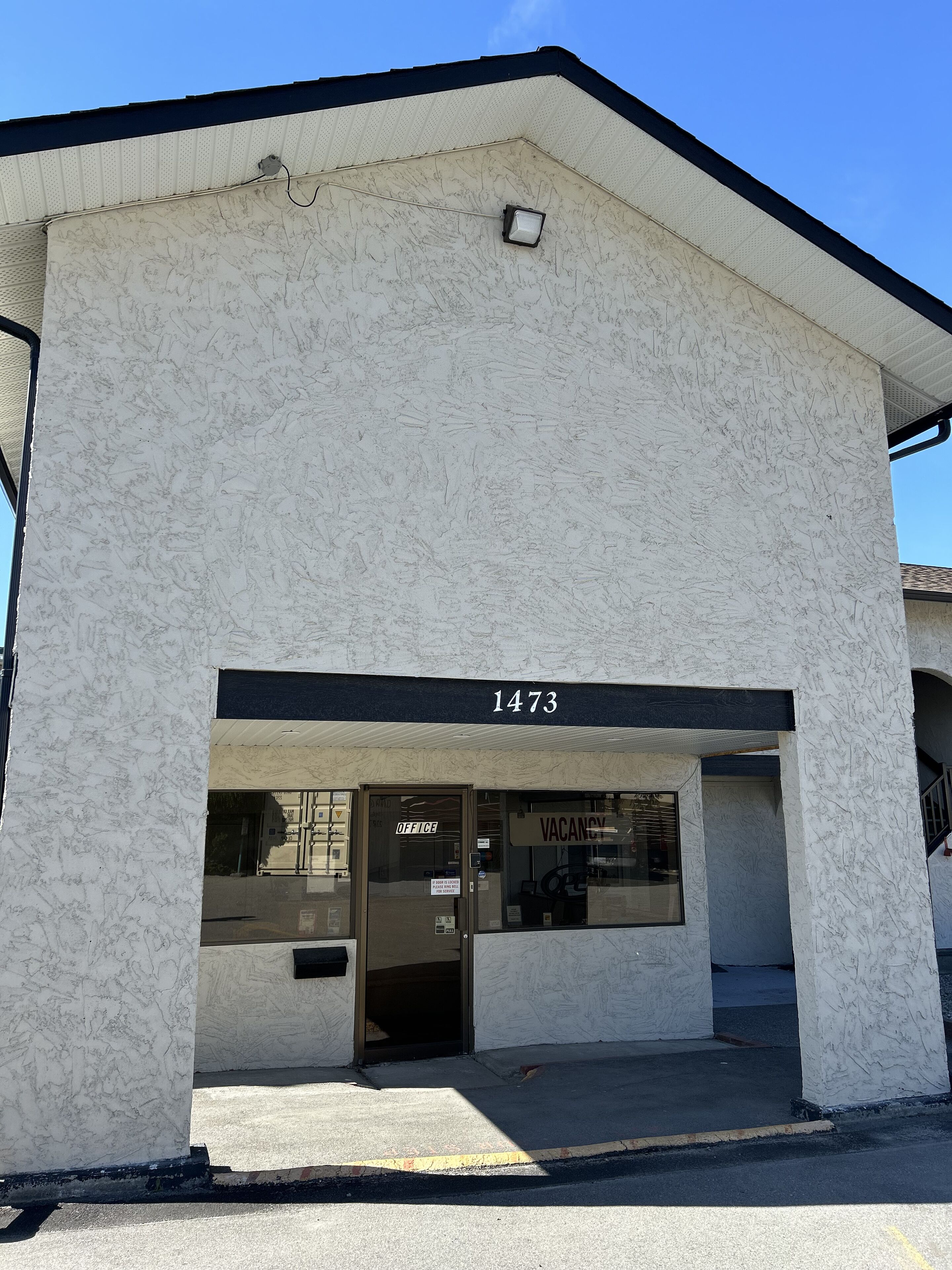 Un edificio con fachada blanca y techo negro. Se ve el número 1473 sobre la entrada.