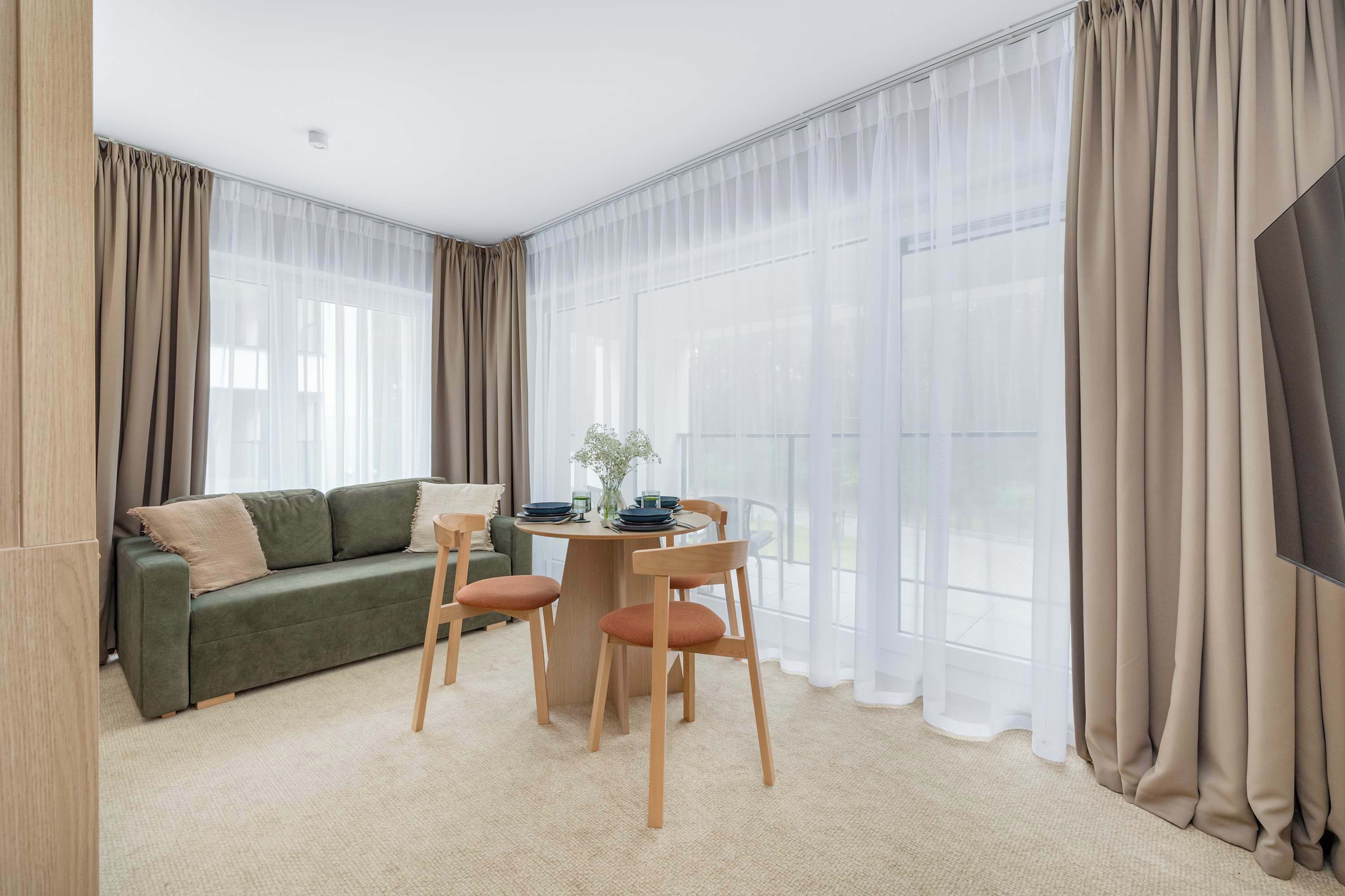 Cozy living room with sofa bed, dining area and access to the balcony.