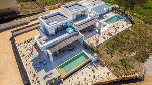 A modern villa with multiple swimming pools, outdoor seating, and a spacious patio area. - Villa Castello: Pool with Sea and Castle Views (Partinico)
