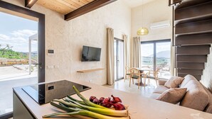 A modern kitchen with a wooden ceiling, a large window, and a dining area with a sofa and chairs. - Villa Castello: Pool with Sea and Castle Views (Partinico)
