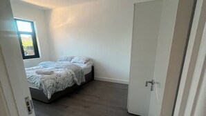 A bedroom with a bed, a window, and a door. - Sunny Gardens London House Retreat (London)