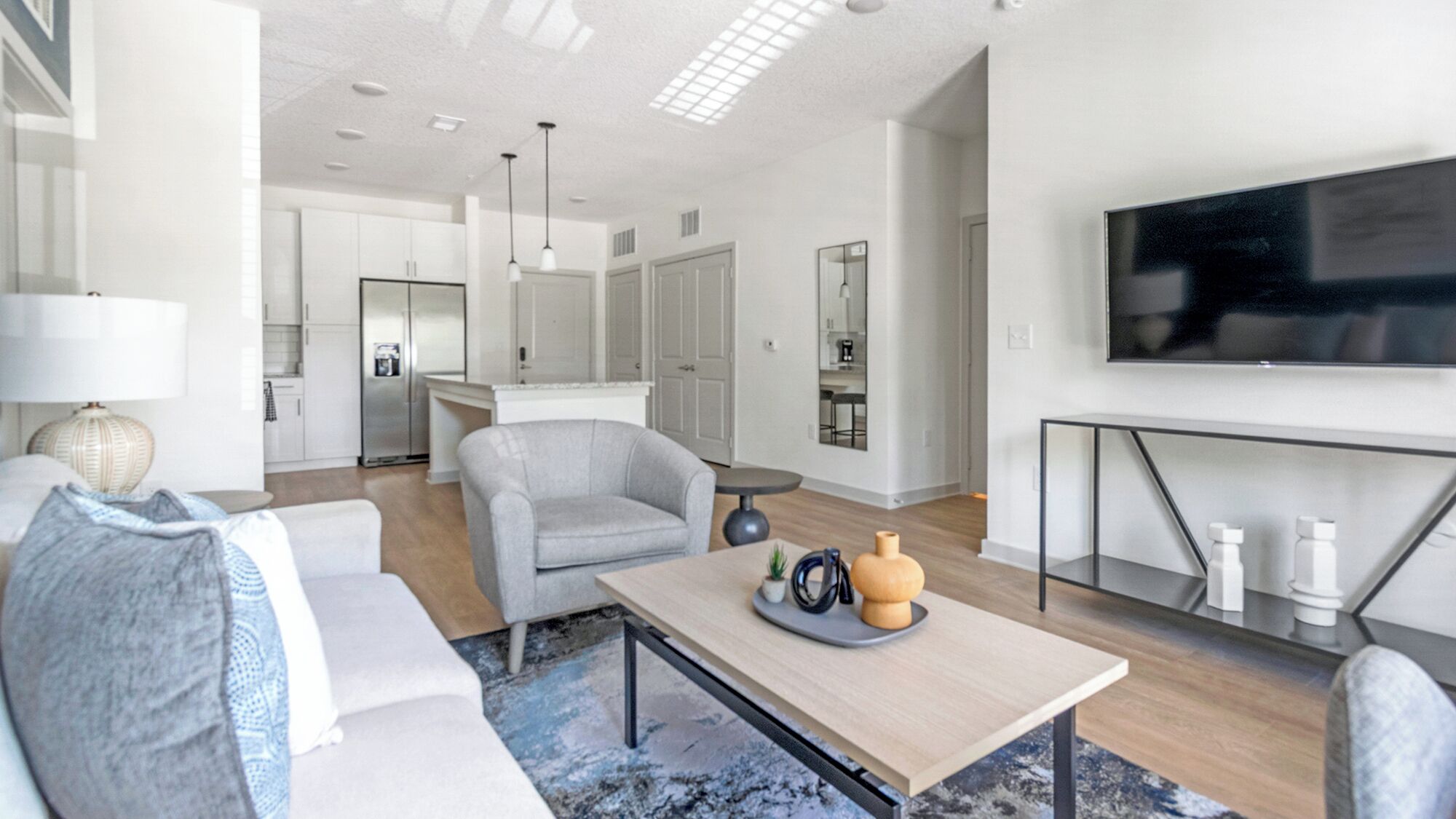 A modern living room with a sofa, coffee table, and a TV on a stand.