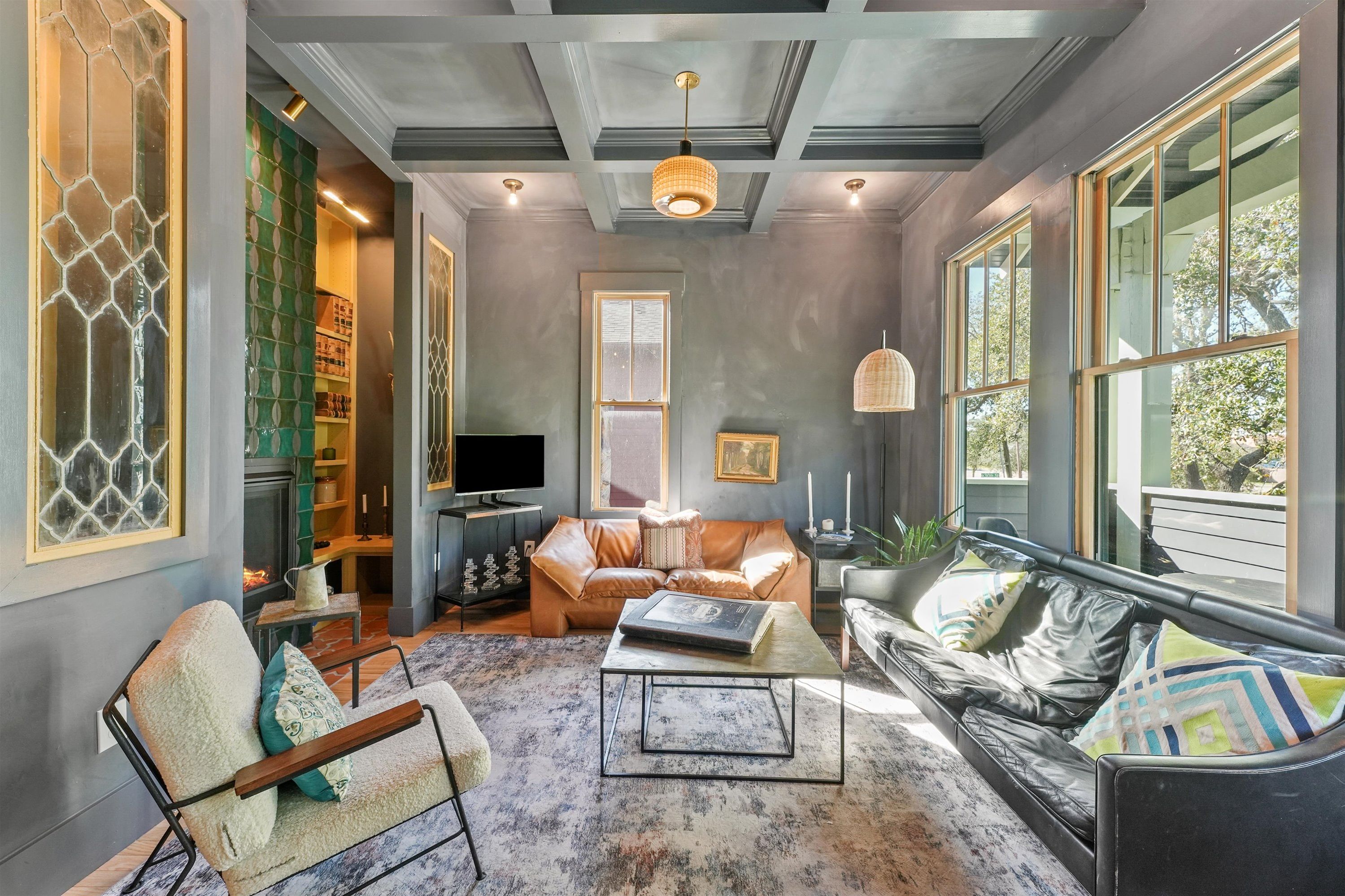 A cozy living room with a fireplace, leather sofa, and a coffee table.