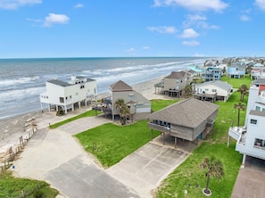 Un quartier résidentiel en bord de mer, avec des maisons situées à proximité de la plage, qui présente un mélange d’architecture moderne et traditionnelle et offre une vue dégagée sur l’océan.