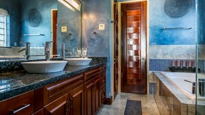 Un bagno moderno con due lavandini, un ampio specchio e una vasca.