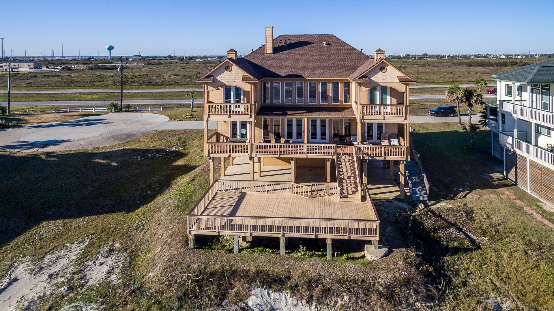 Una casa de dos pisos con un amplio balcón y varios balcones.