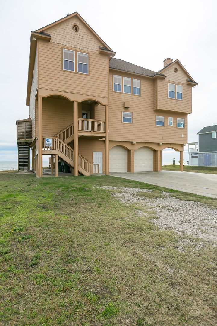 A two-story house with a balcony, a garage, and a staircase leading to the upper floor.