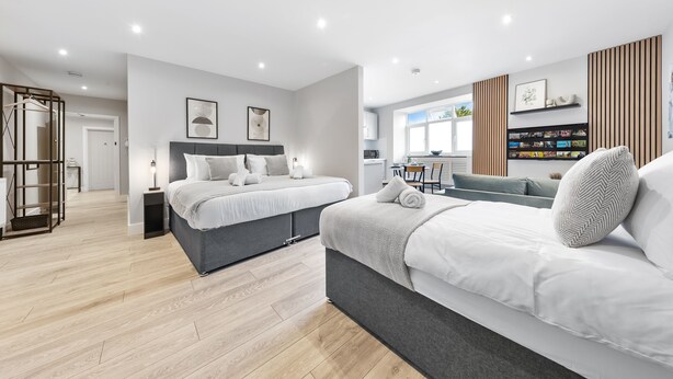 Une chambre moderne avec un grand lit, des tables de chevet et une armoire intégrée.