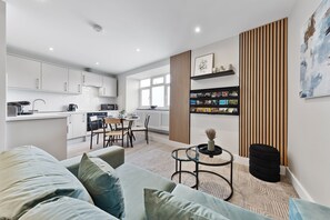 A modern living space with a kitchen, dining area, and a cozy seating area with a sofa and a small coffee table.