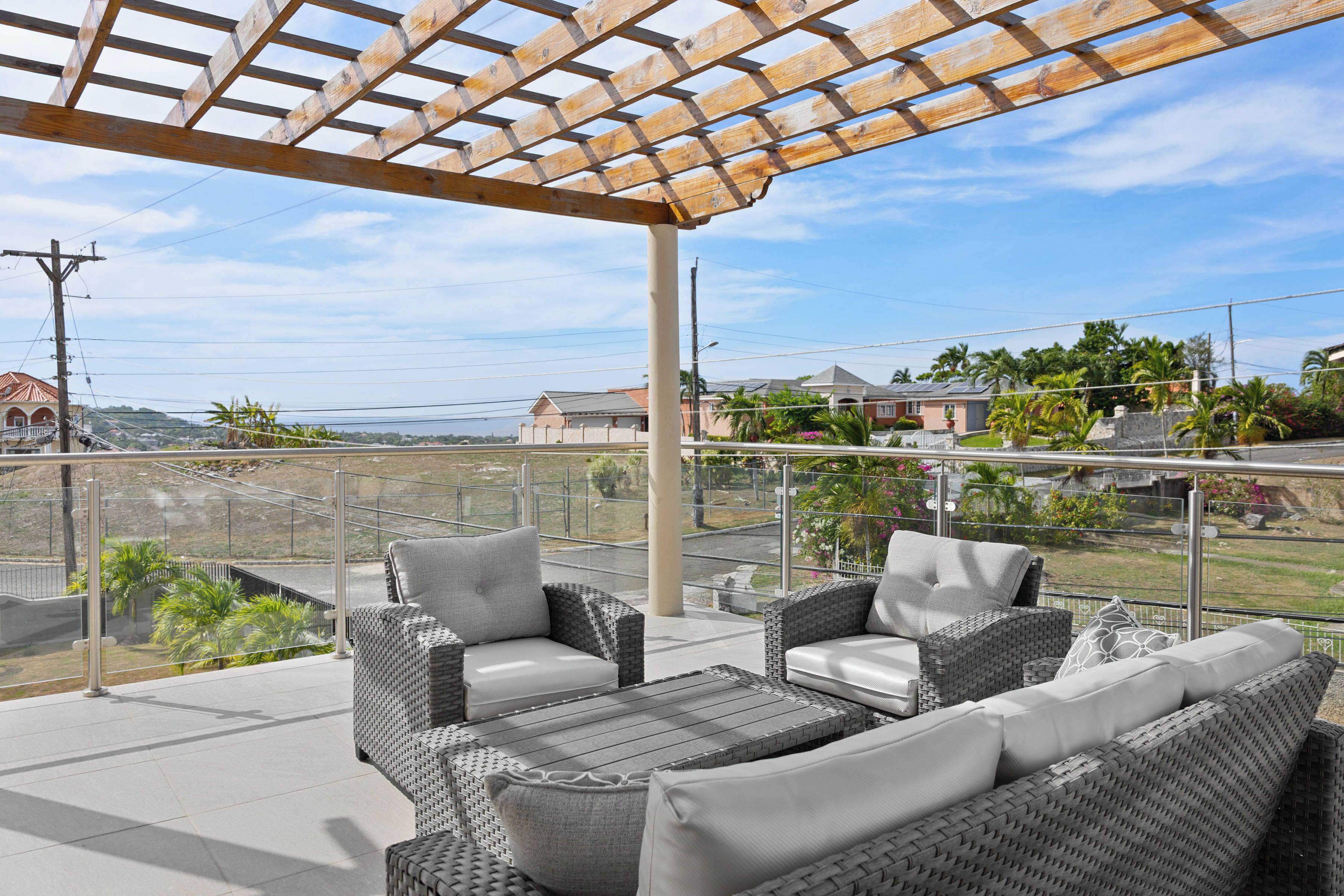 An outdoor patio with wicker furniture and a pergola.