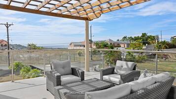 An outdoor patio with wicker furniture and a pergola.