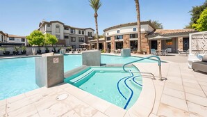 A swimming pool with a no diving sign, surrounded by lounge chairs and palm trees, with buildings in the background. - Boulevard Stays Chic 1BR Near Stadium Pool Access, Gym & Free Parking (Glendale)