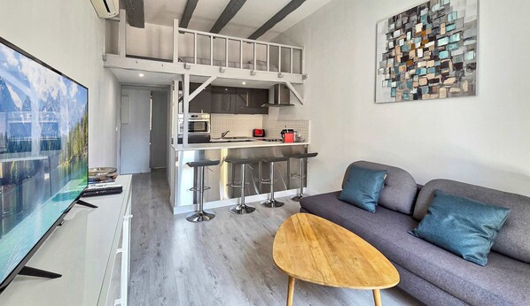 A modern apartment with a kitchen, dining area, and living room.
