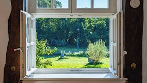 Una habitación con un ventanal grande que da a un jardín exuberante.