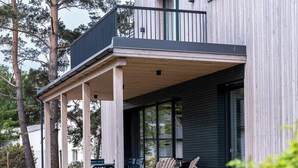 A modern house with a covered porch, wooden deck, and outdoor seating. - Aloha Pruchten (Pruchten)