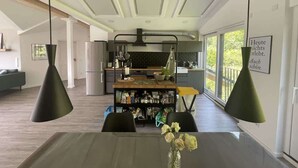 A modern kitchen with a wooden island, pendant lights, and a view of the outdoors. - "Smart Apartment" Heidelberg (Heidelberg)