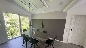 A modern dining area with a glass table, black chairs, and pendant lights. - "Smart Apartment" Heidelberg (Heidelberg)