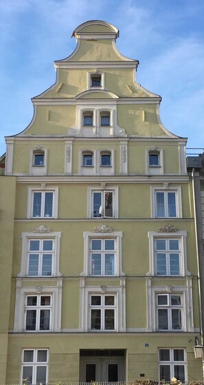 A multi-story building with a classical architectural style, featuring symmetrical windows and decorative moldings. - Stralsund Altstadt, 2-Zi-Wohnung mit Loggia (Stralsund)