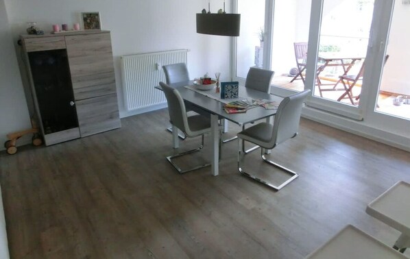 A modern kitchen with a dining table, chairs, and a built-in appliance.