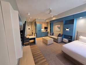 Une chambre d’hôtel moderne équipée d’un lit, d’un canapé, d’une table à manger et d’une kitchenette.
