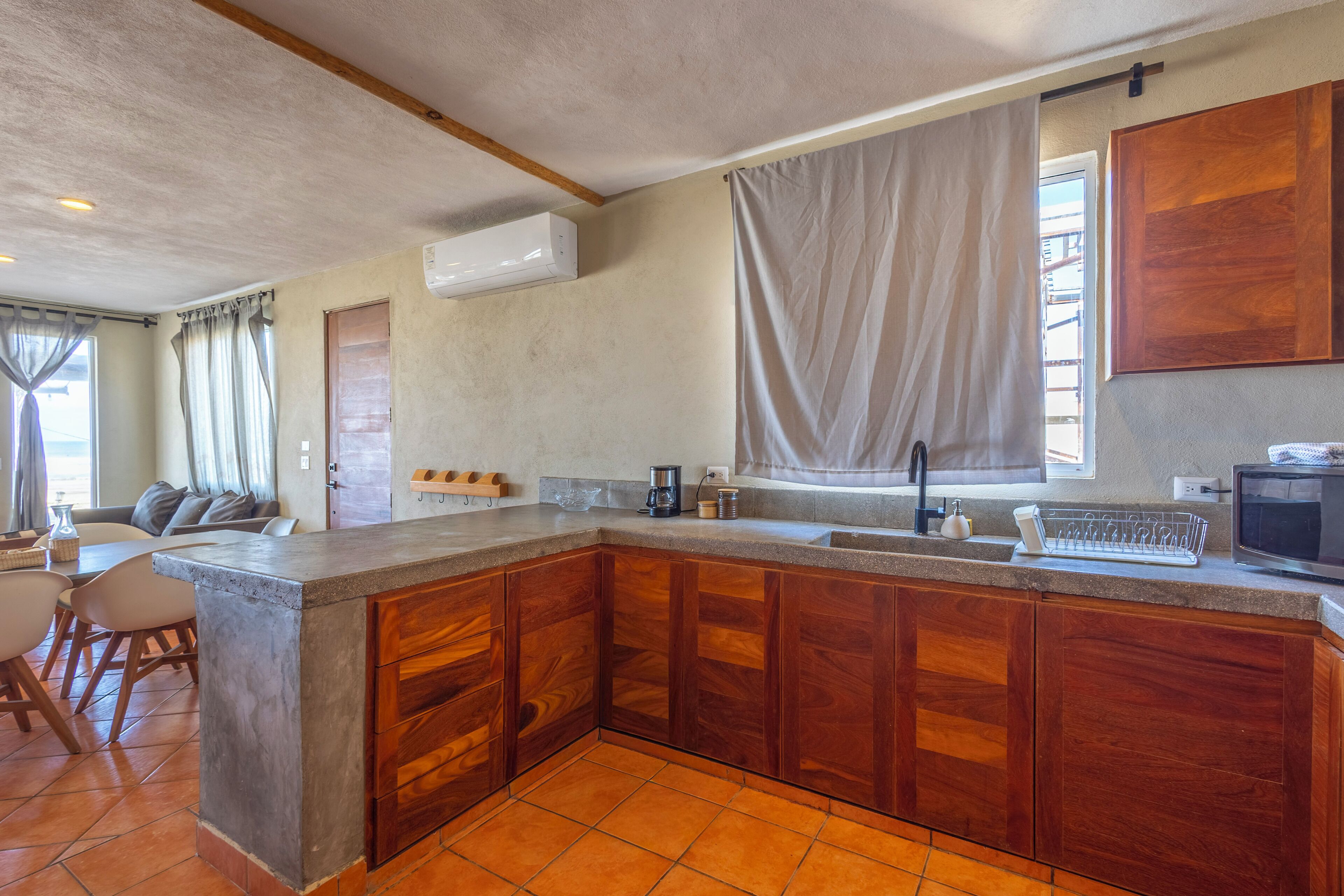 Una cocina con armarios de madera, encimera de granito y pileta integrada.