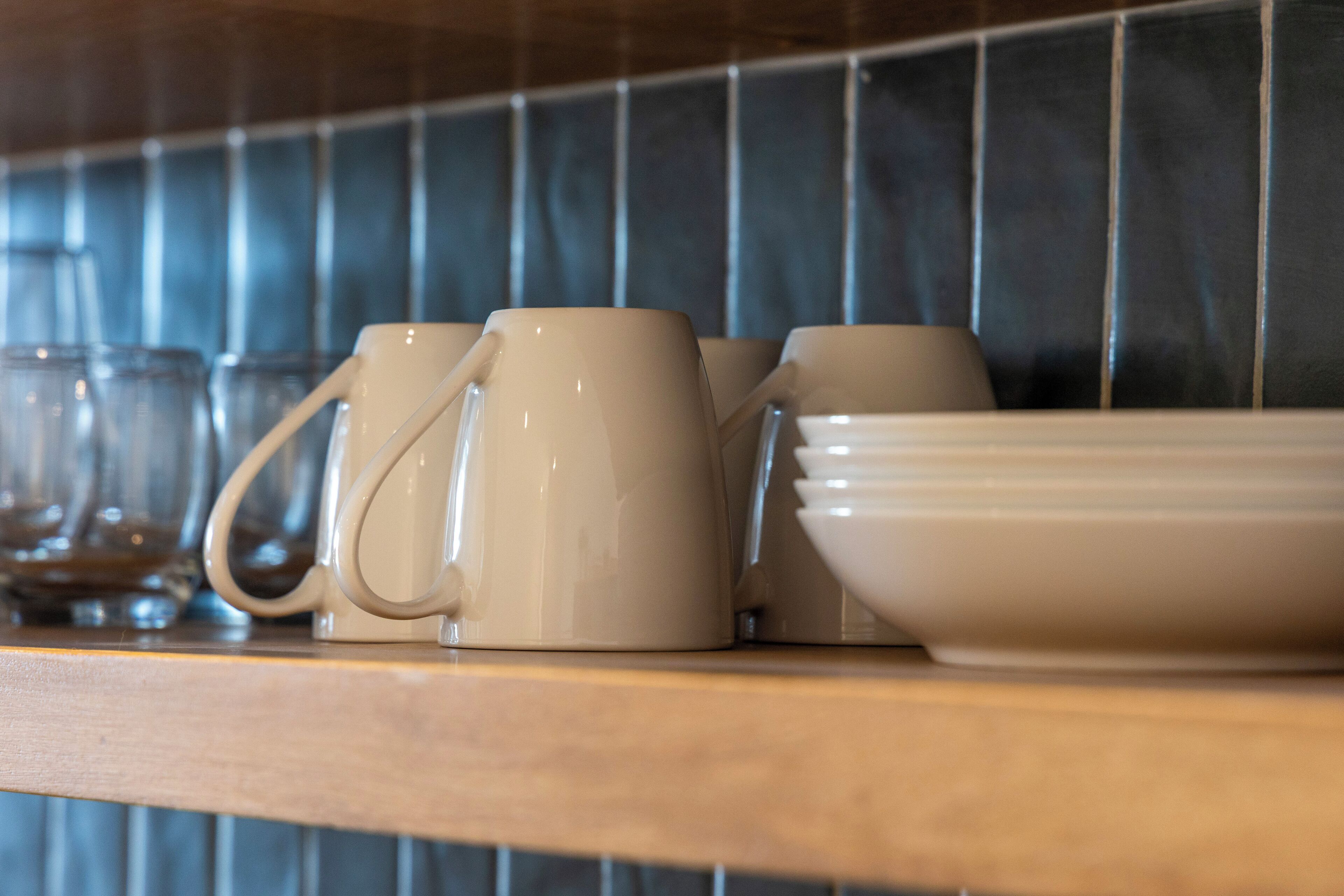 A kitchen counter with various ceramic mugs and bowls.