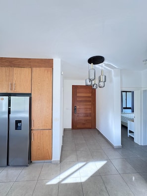 A modern kitchen with a built-in refrigerator and wooden cabinets.