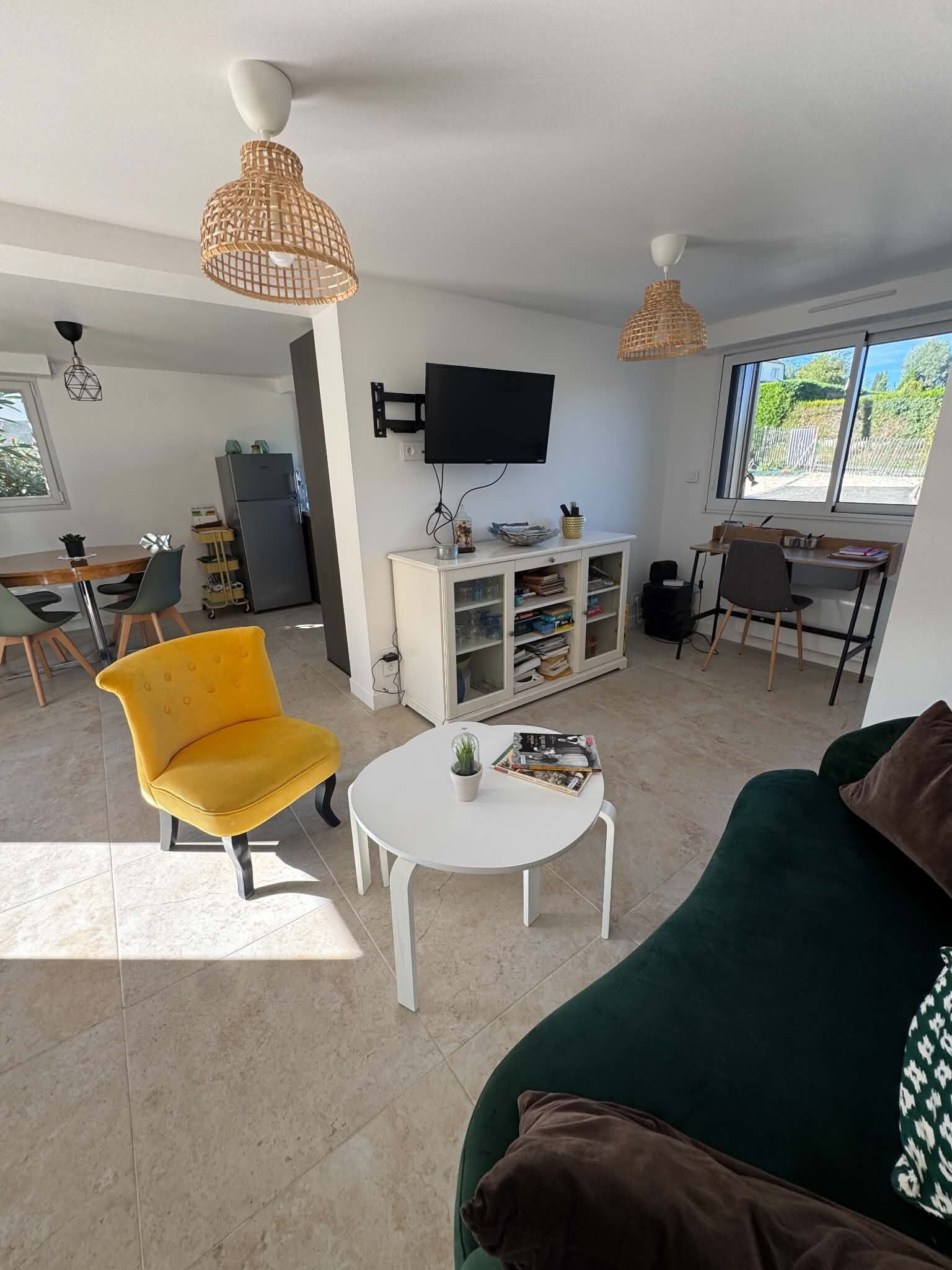 Ein modernes Wohnzimmer mit einem gelben Sessel, einem weißen Couchtisch und einem grünen Sofa.