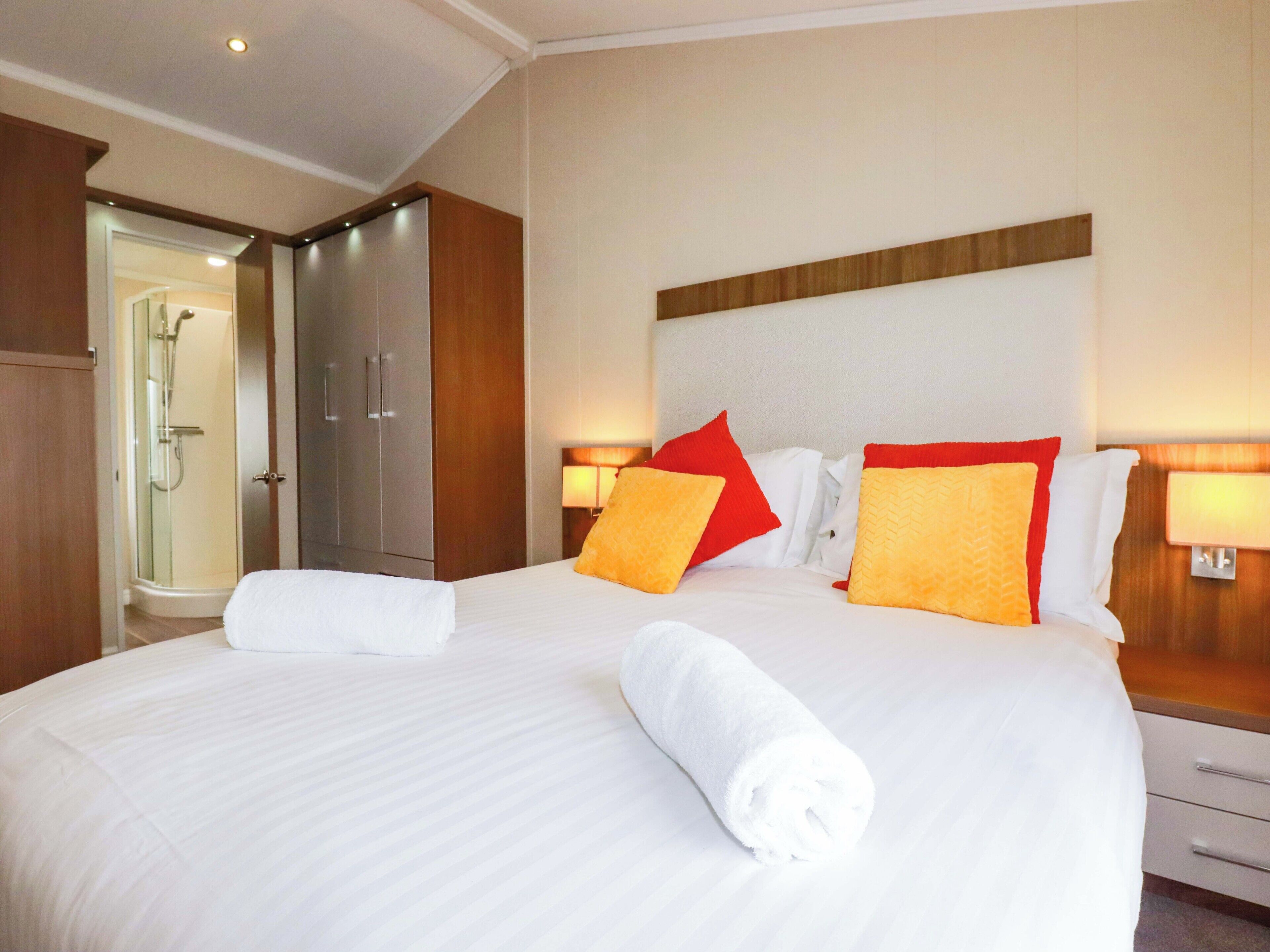 Una habitación de hotel con una cama grande, un cabecero de madera y un vestidor.